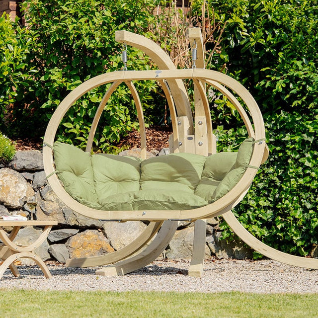 beautiful wooden hand-crafted hanging chair in a green garden 